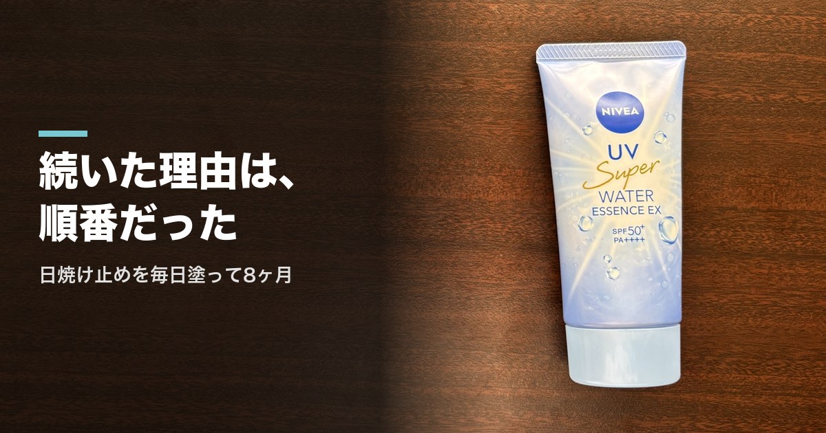 木のテーブルに置いたニベアUV ウォーターエッセンスEXのチューブ